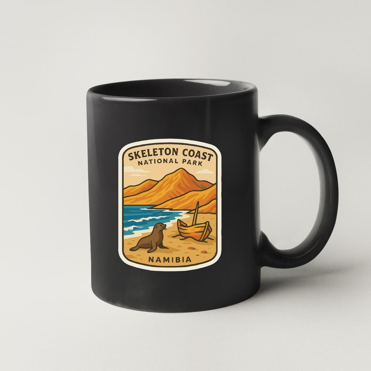 A black coffee mug with a label that says "Skeleton Coast National Park Namibia".