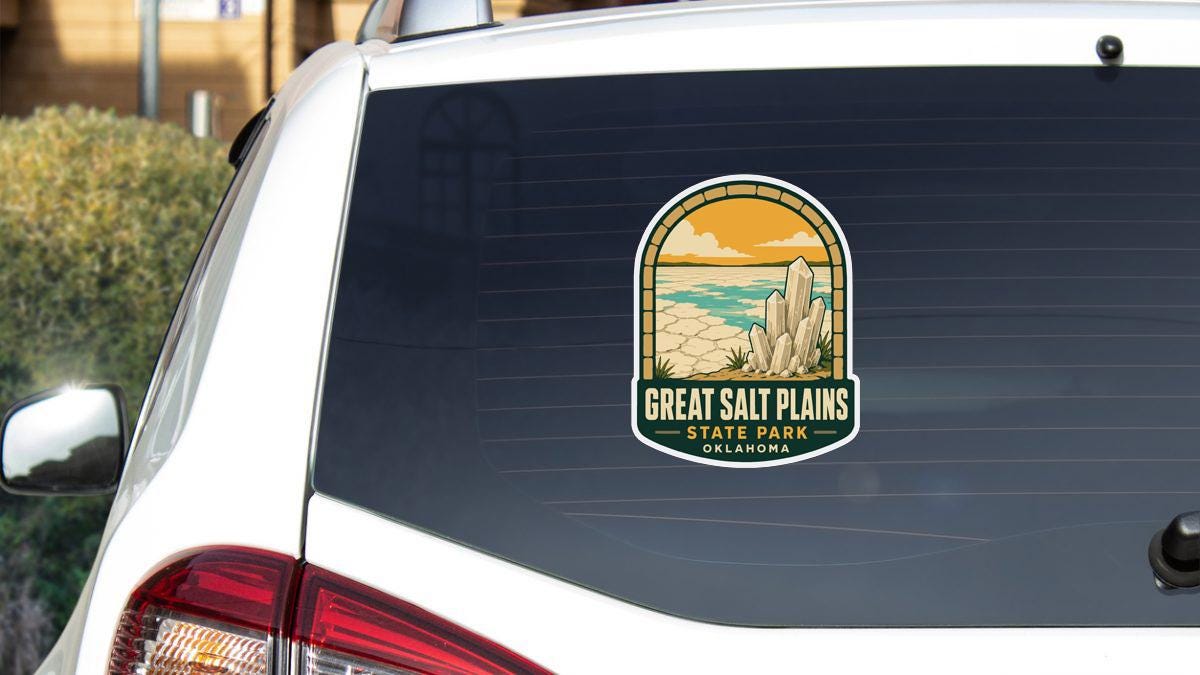 A sticker on the rear window of a white vehicle, depicting a scenic landscape with mountains and a body of water.