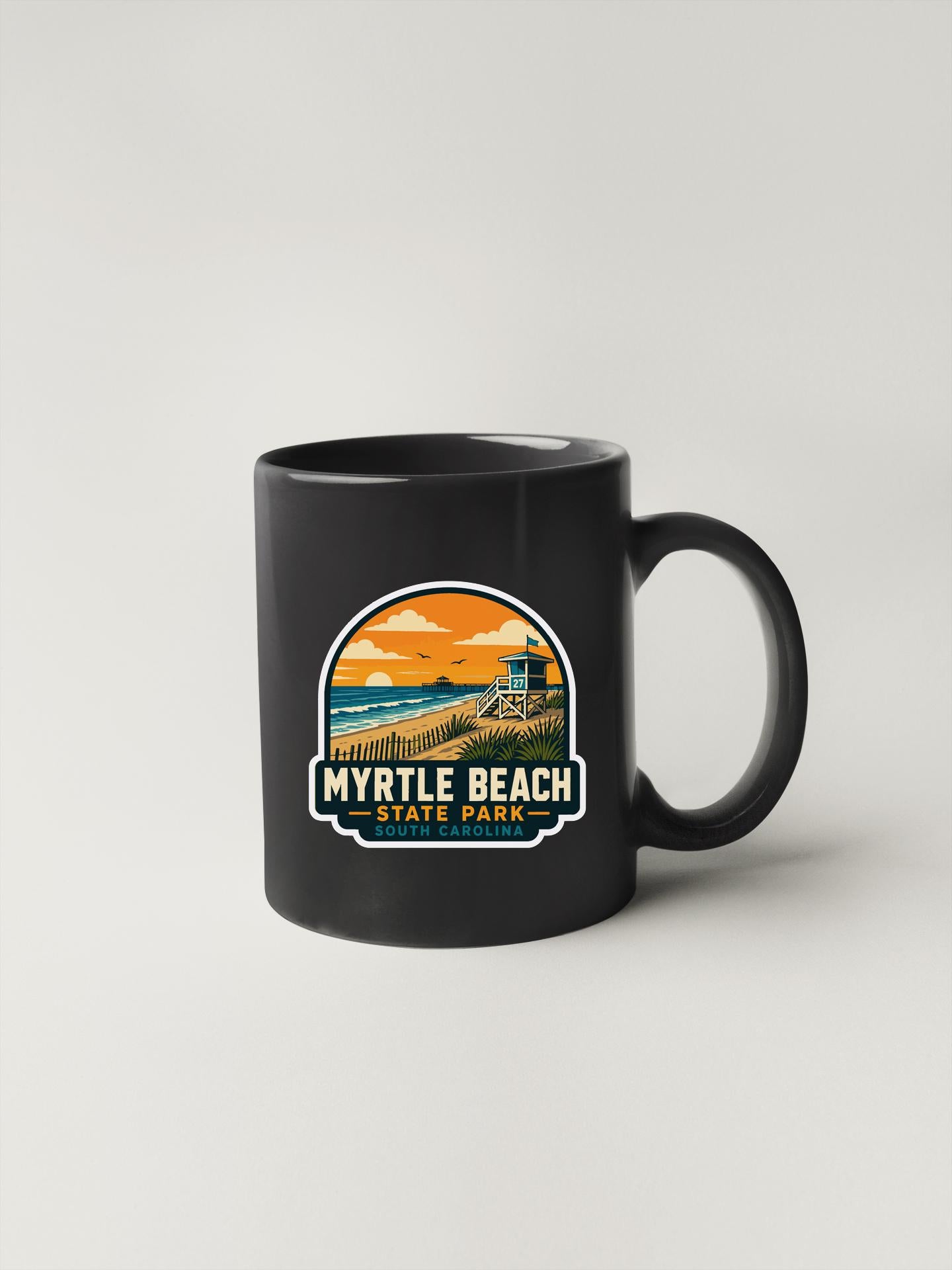 A black coffee mug with a graphic design depicting a beach scene and the text "Myrtle Beach State Park" printed on it.