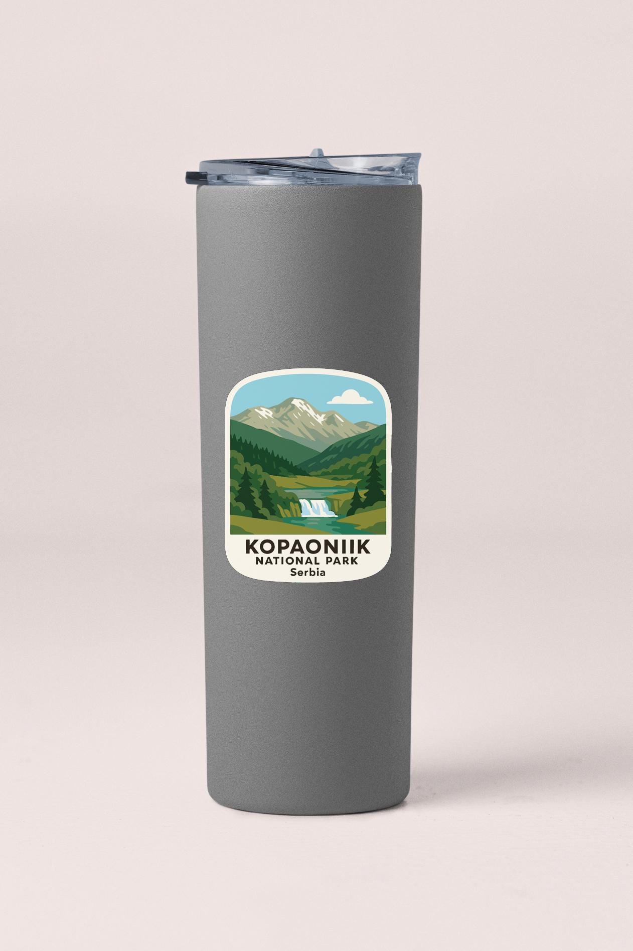 A gray insulated tumbler with a sticker depicting a scenic mountain landscape and the text "Kopanik National Park, Serbia".