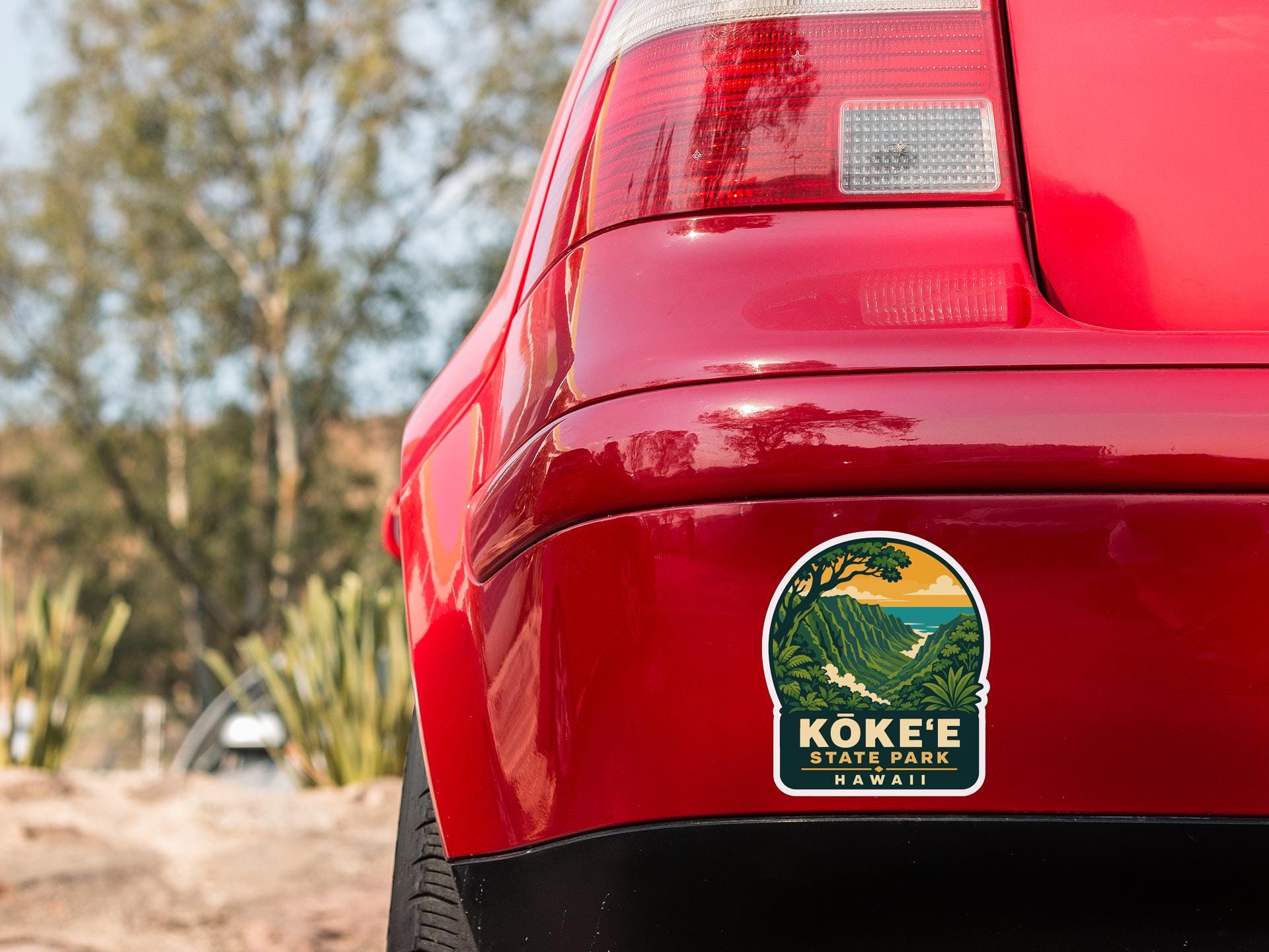 the rear end of a red car with a sticker on the back window that says "Koke'e State Park Hawaii".