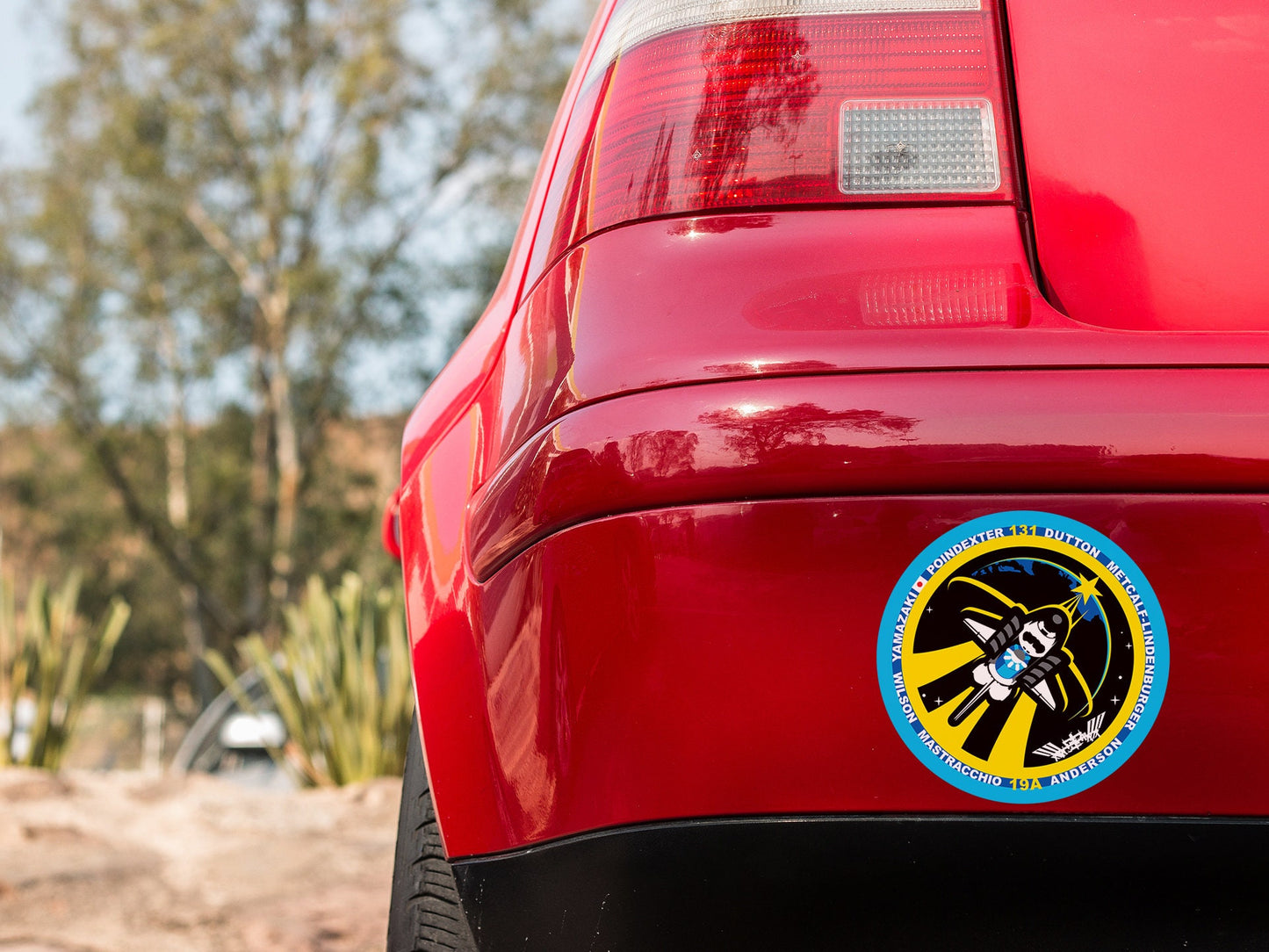 a close up of a red car with a sticker on it