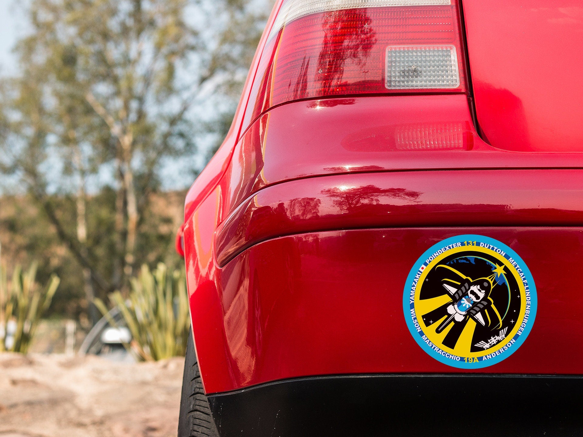 a close up of a red car with a sticker on it