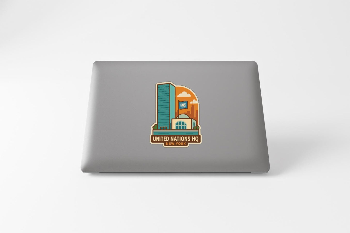 a sticker on the back of a laptop that displays a stylized illustration of a building, along with the text "UNITED NATIONS HQ" and "UNITED NATIONS".