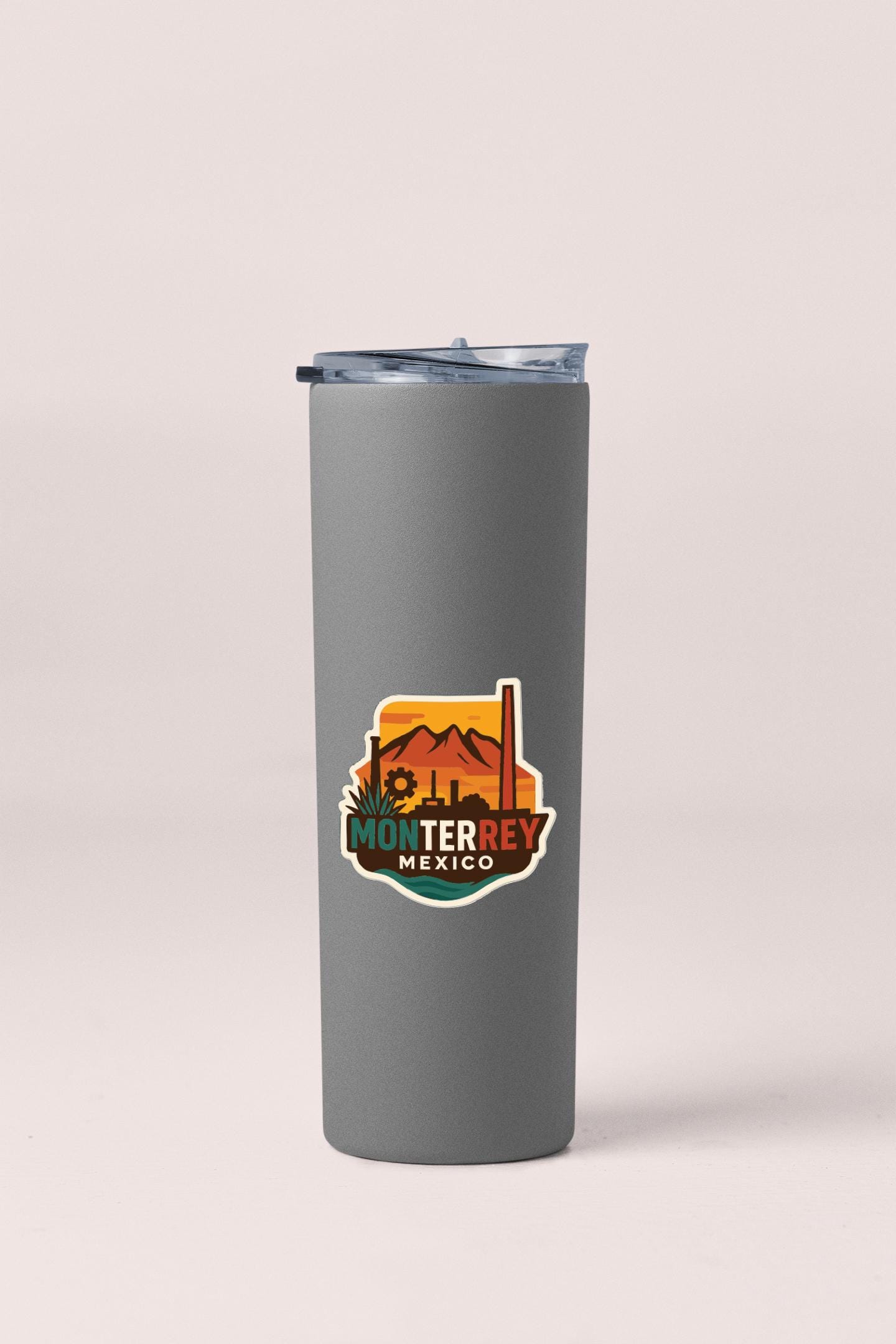 A gray insulated tumbler with a lid and a colorful logo that says "MONTERREY MEXICO".