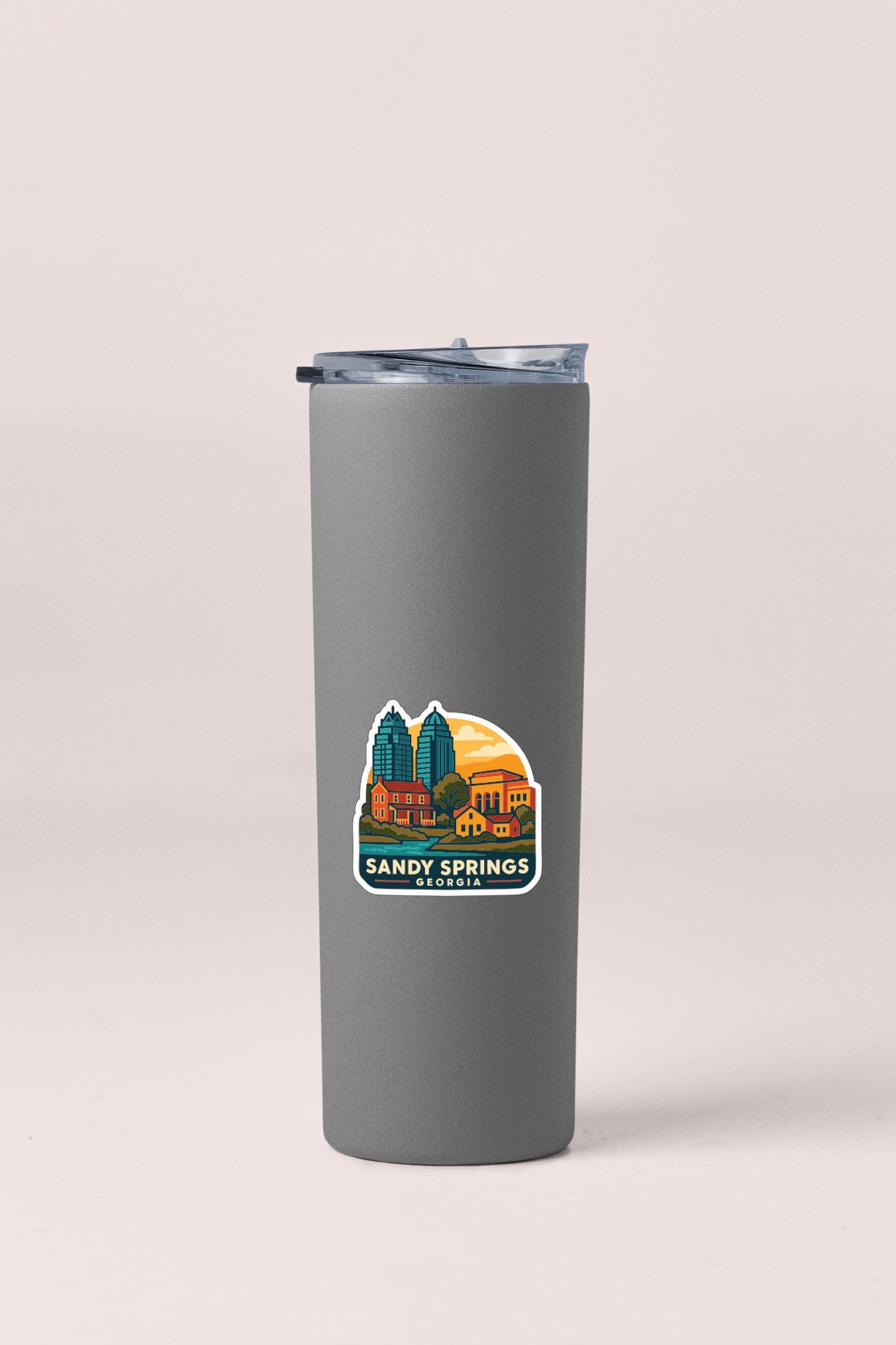 A gray insulated tumbler with a sticker depicting a city skyline and the text "SANDY SPRINGS GEORGIA".