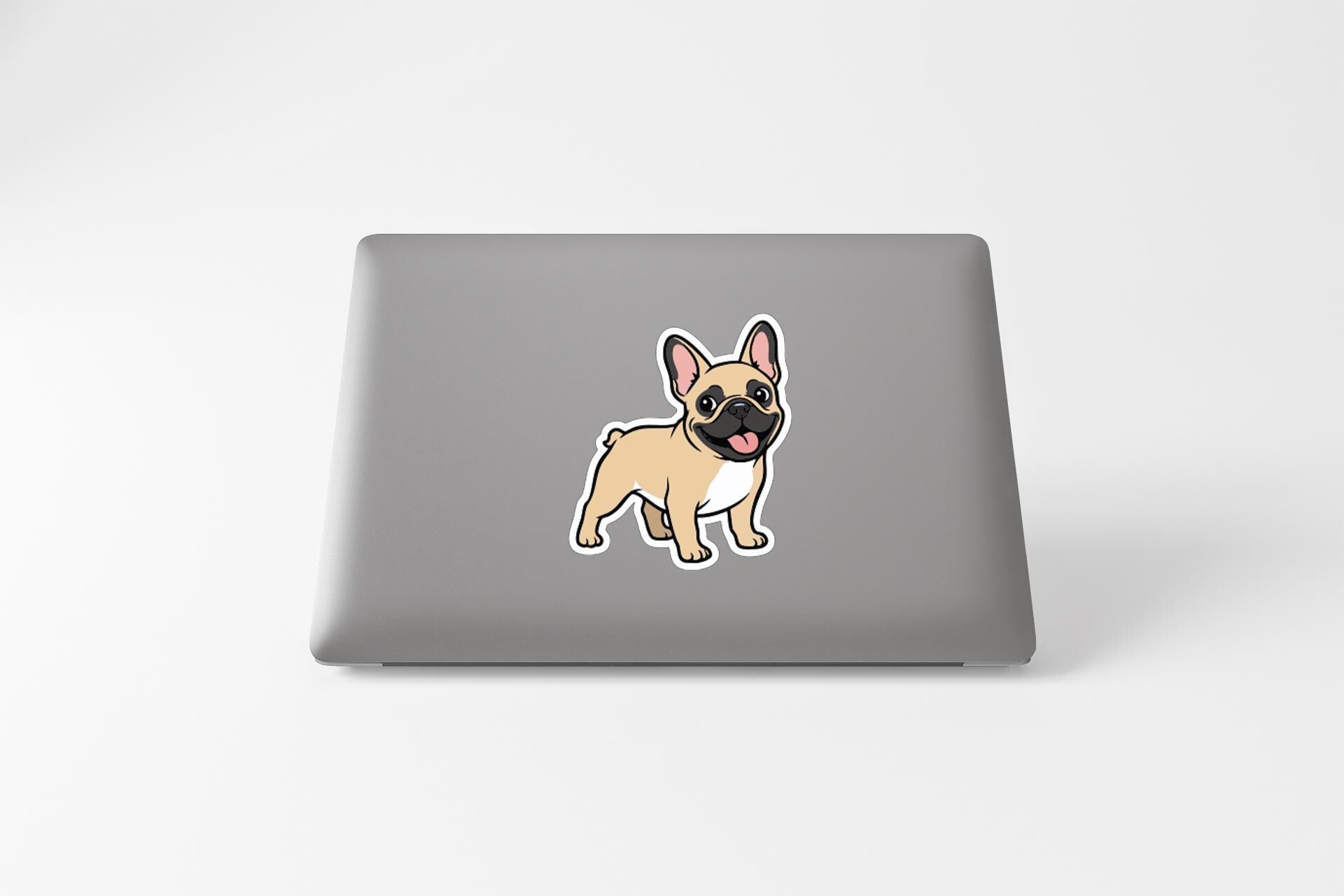 A sticker of a cartoon dog on the back of a laptop computer.