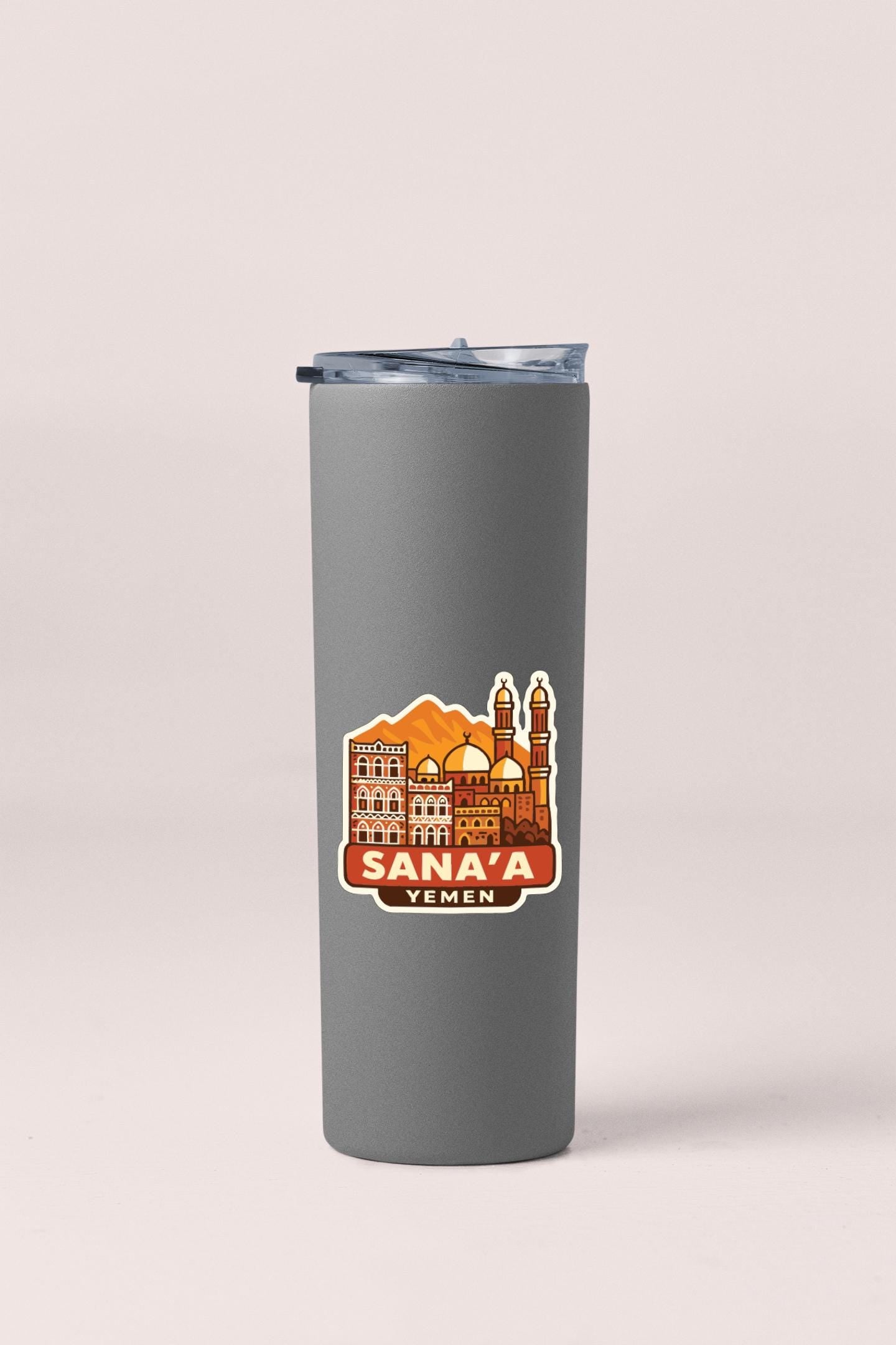 A gray insulated tumbler with a sticker depicting the Sana'a skyline in Yemen.
