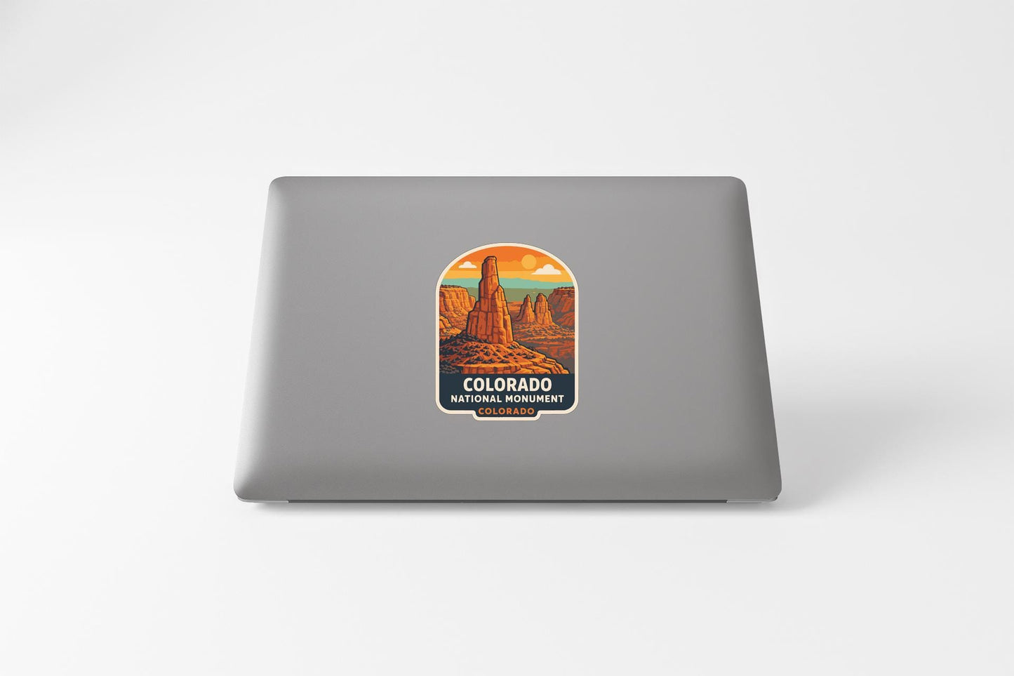 A sticker depicting a scenic landscape with mountains and a desert, featuring the text "COLORADO NATIONAL PARK" and "COLORADO" at the bottom.