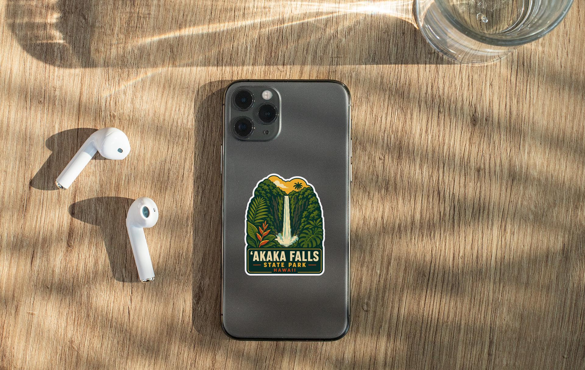 a smartphone with a sticker on it, placed on a wooden surface alongside a pair of white earbuds and a glass of water.