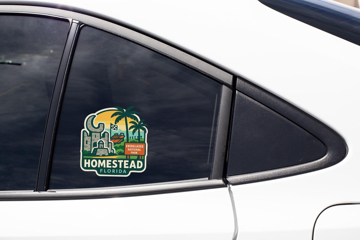 a sticker on the side of a car window, featuring a tropical landscape with palm trees and a building, along with the text "HOMESTAD FLORIDA" indicating the location.