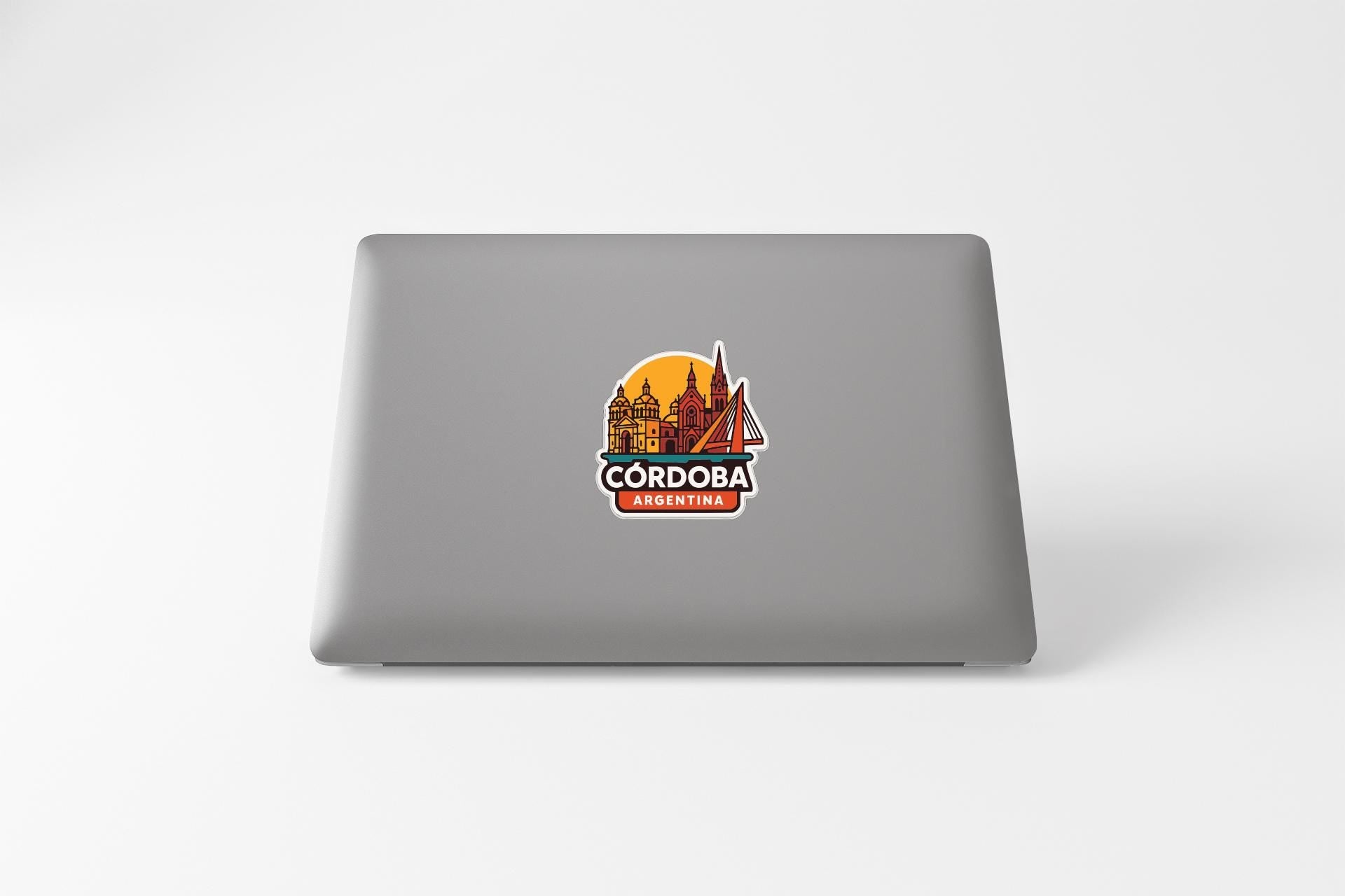 a sticker with a cityscape and the text "CORDOBA" on the back of a laptop.