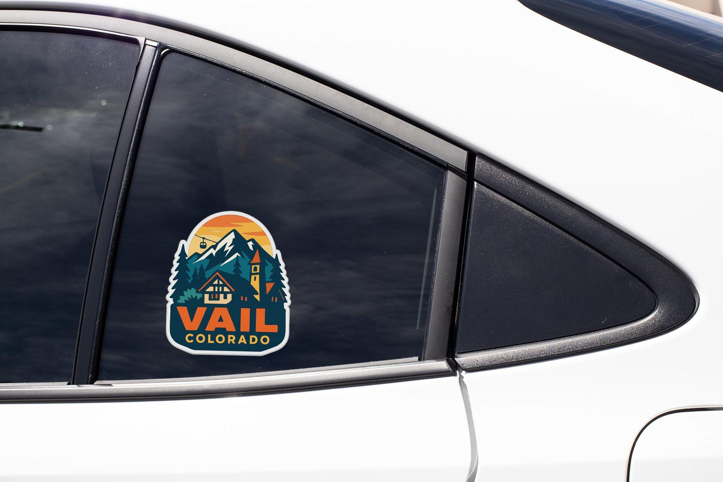 A sticker on the side of a car window, featuring a mountain landscape with a house and the text "Vail Colorado".