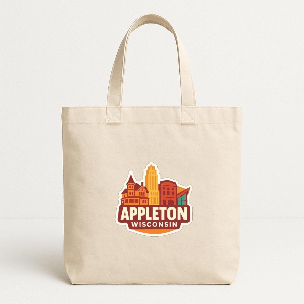 A beige tote bag with a graphic design featuring the text "APPLETON WISCONSIN" and an illustration of a city skyline.