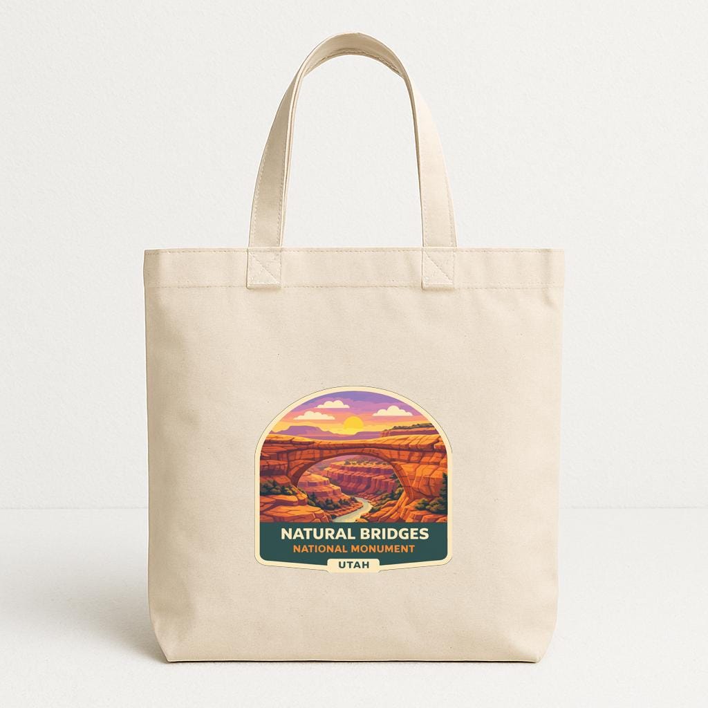 A beige tote bag with a graphic design depicting the Natural Bridges National Monument in Utah.