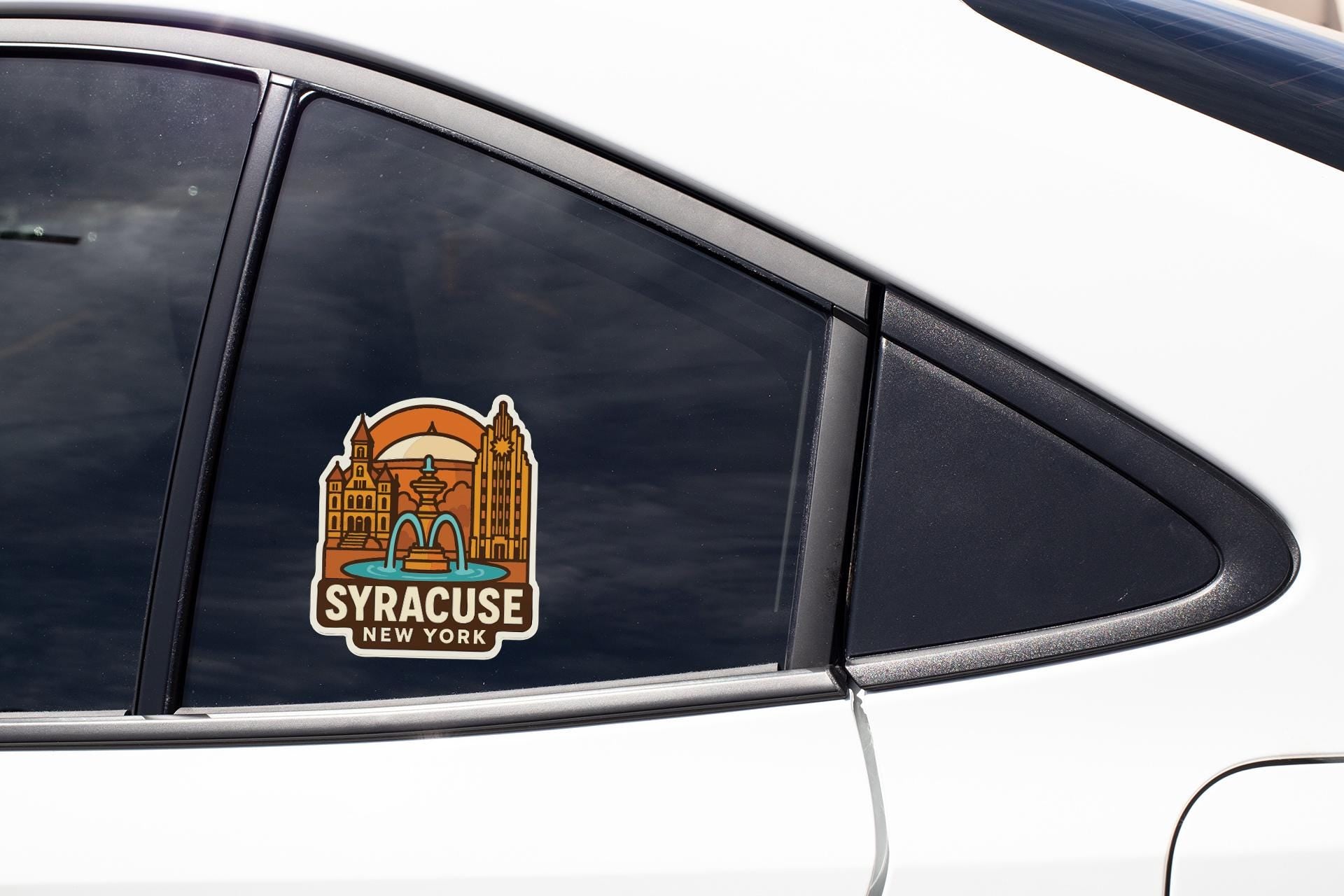 A sticker on the side of a car window, depicting a cityscape with a fountain and the text "Syracuse, New York".