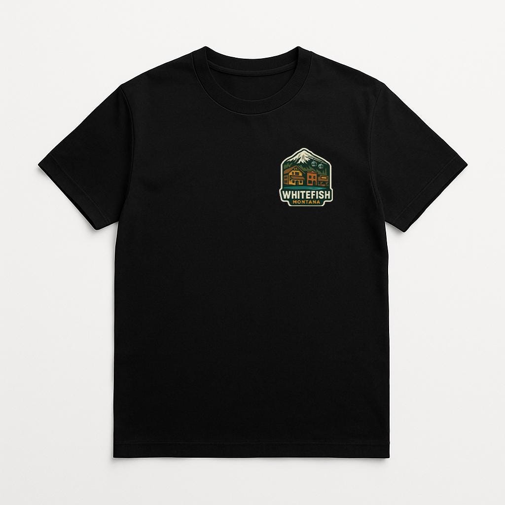 A black t-shirt with a graphic design on the front, featuring a mountain and the text "WHITEFISH" in a stylized font.