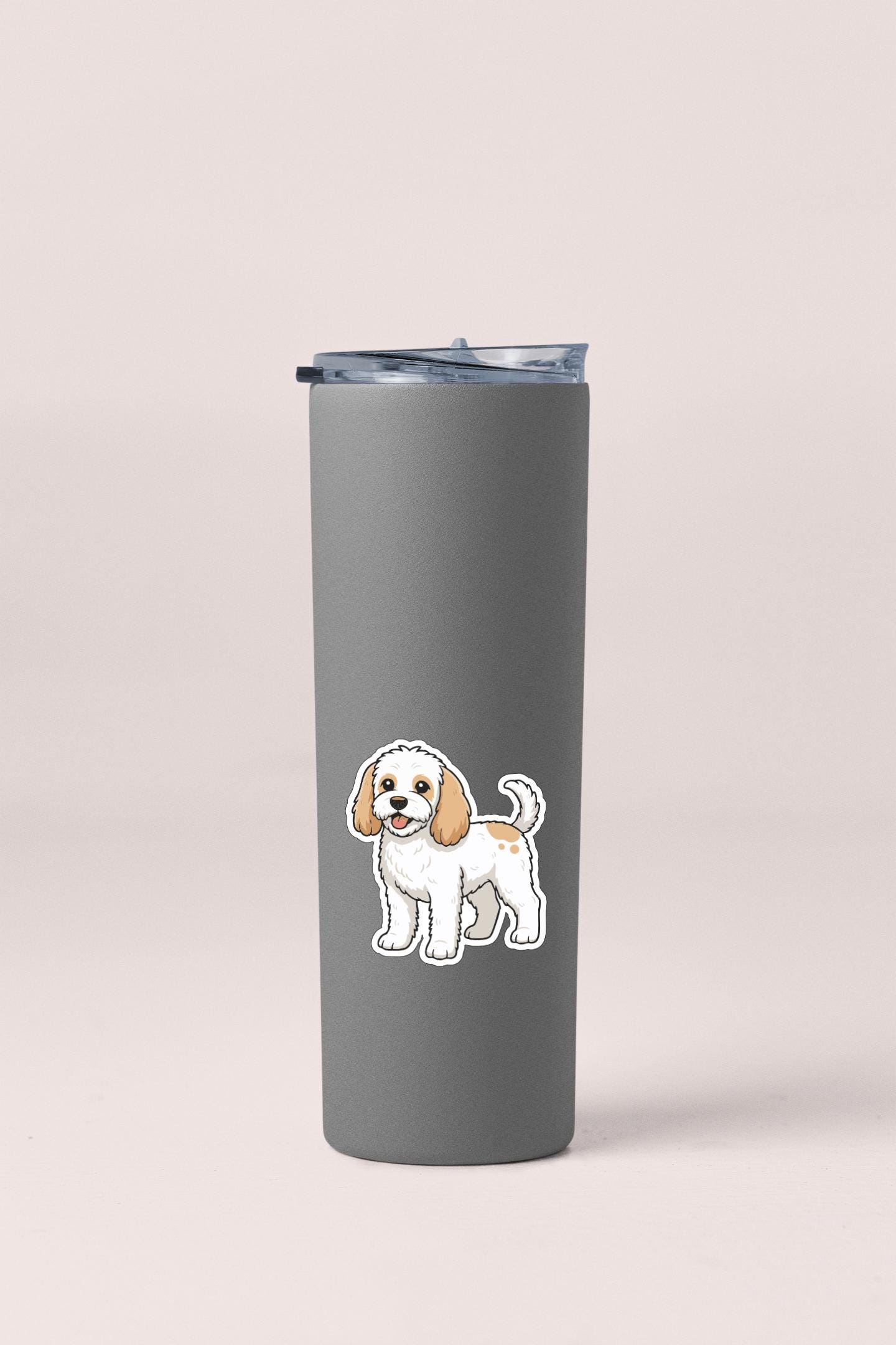 A gray insulated tumbler with a cartoon dog sticker on it.