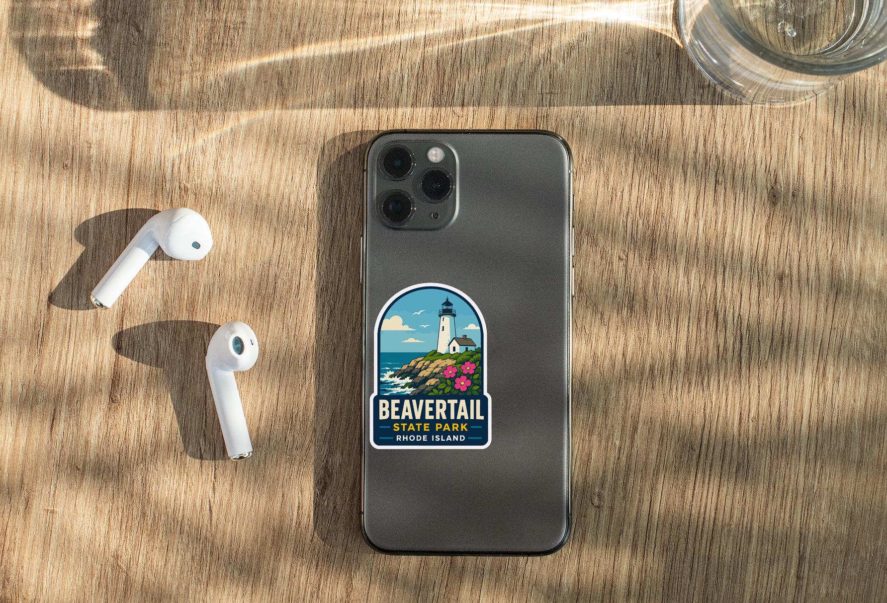 a smartphone with a sticker of Beavertail Beach, Rhode Island, placed on a wooden surface alongside a pair of white earbuds and a glass of water.