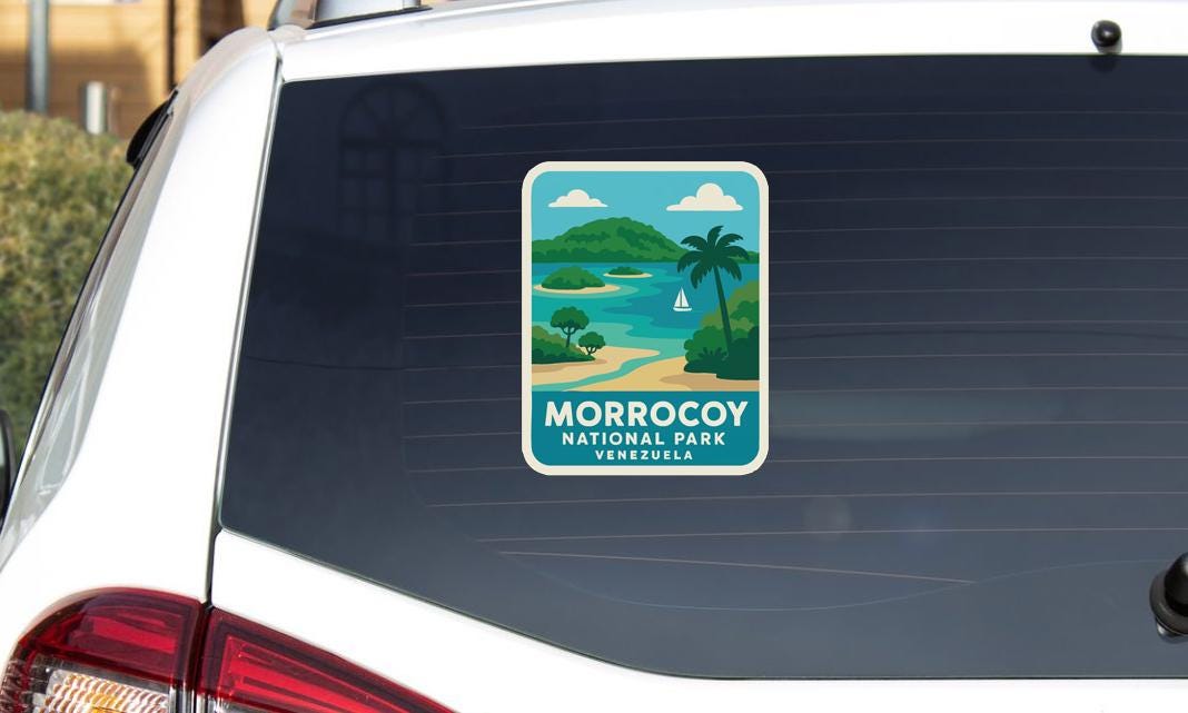 A sticker on the rear window of a car, depicting a tropical landscape with palm trees, a beach, and a sailboat.