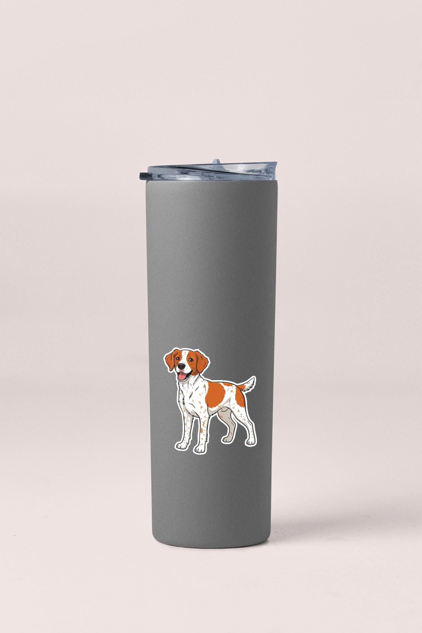 A gray insulated tumbler with a sticker of a dog on it.