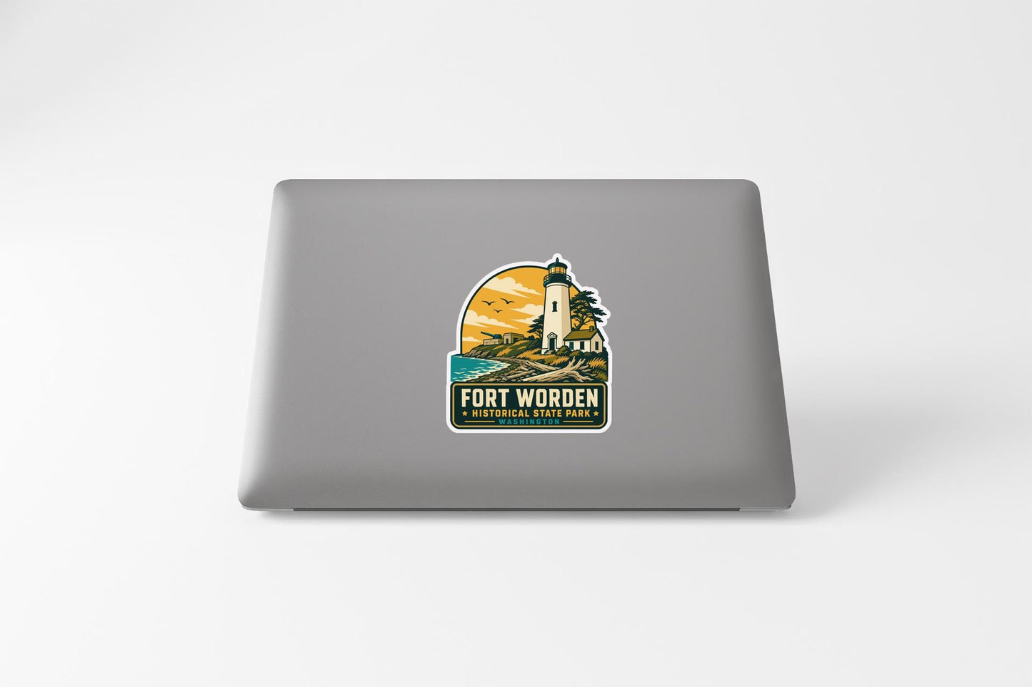 A sticker on the back of a laptop, depicting a lighthouse and a scenic landscape.