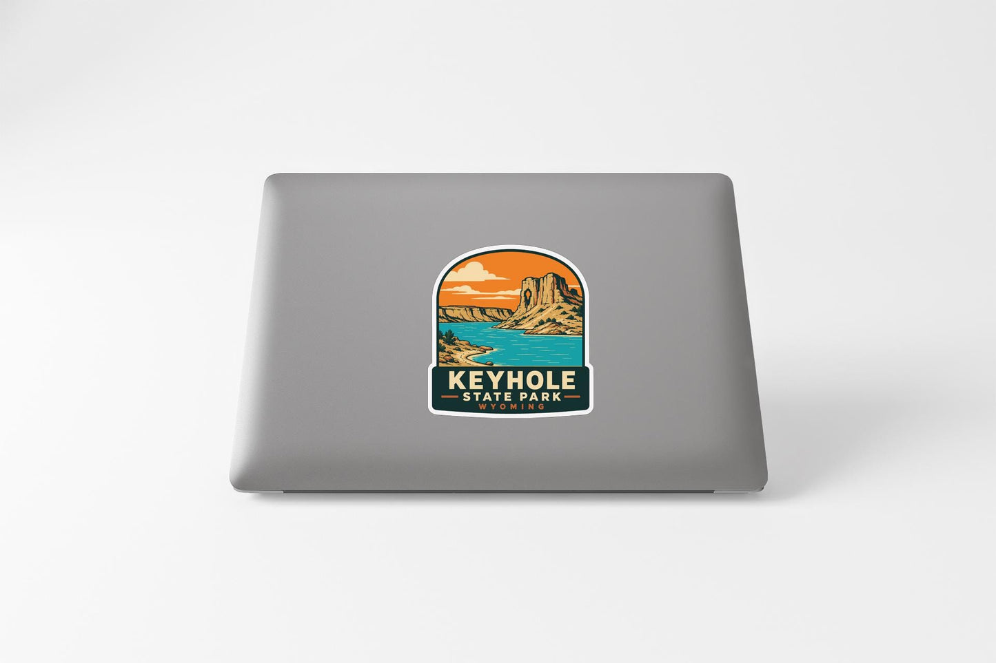 A sticker depicting a scenic landscape with mountains, water, and a sunset, with the text "KEYHOLLE STATE PARK" printed on it.