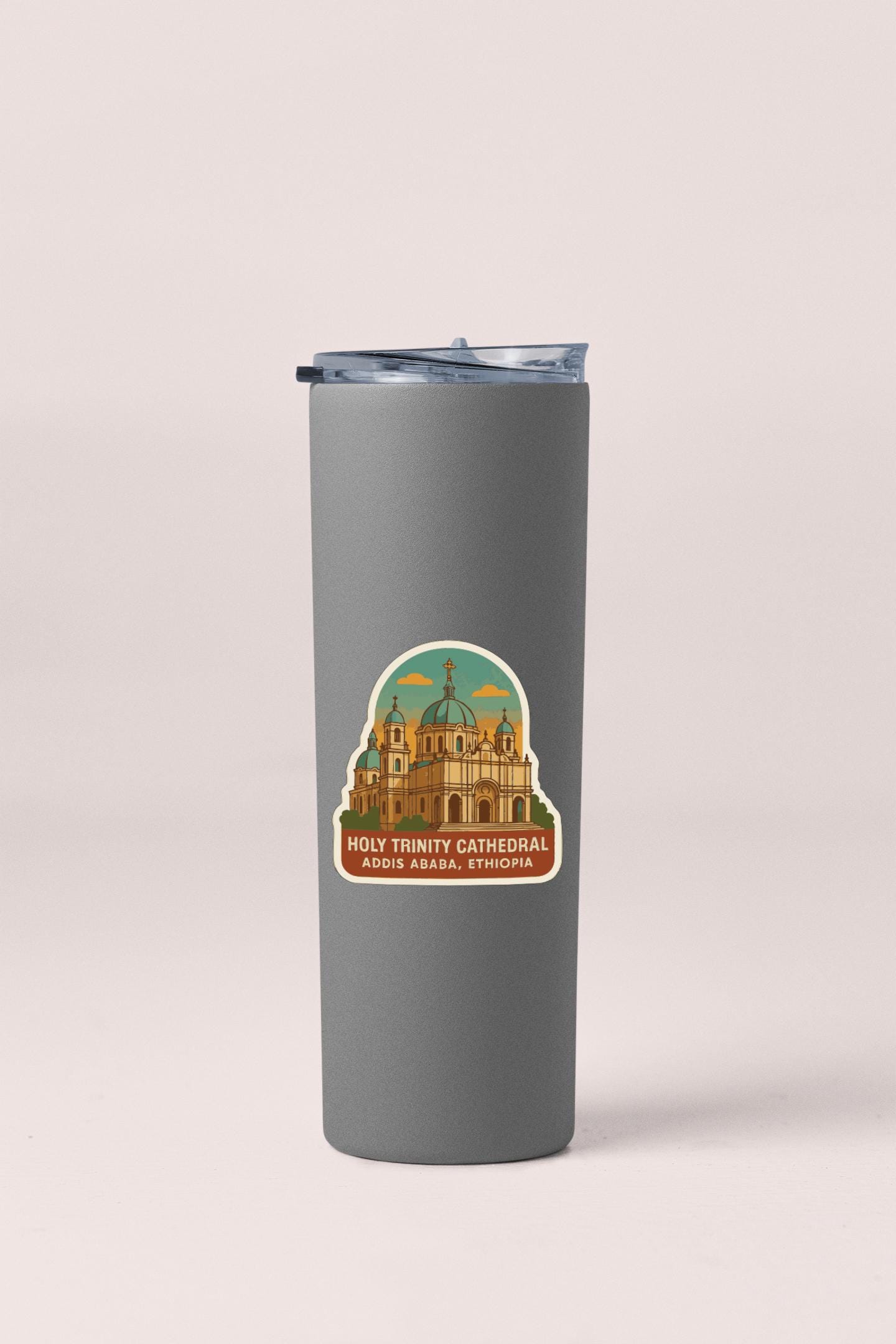 A gray tumbler with a sticker depicting the Holy Trinity Cathedral in Addis Ababa, Ethiopia.