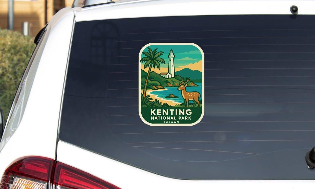 A sticker on the rear window of a car, depicting a lighthouse and a deer in a tropical setting, with the text "KENTING NATIONAL PARK TAIWAN".