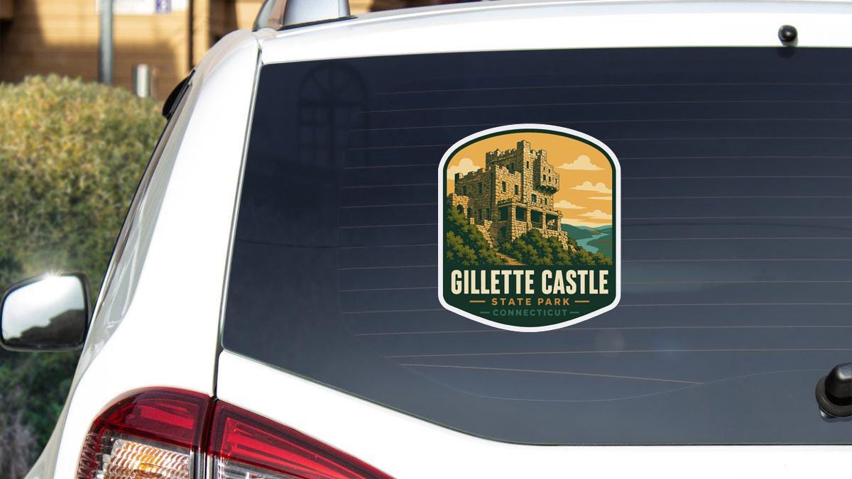 A sticker on the rear window of a white car, depicting a castle on a hill.