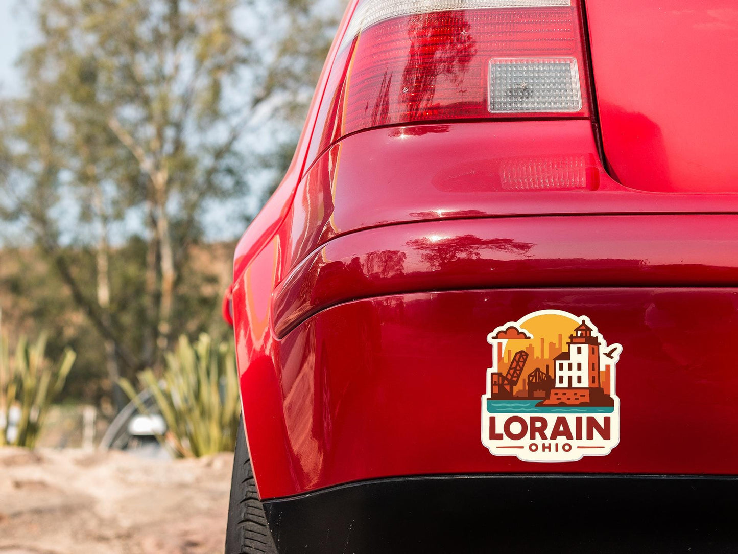 the rear end of a red car with a sticker on the trunk that says "LORAIN, OHIO".