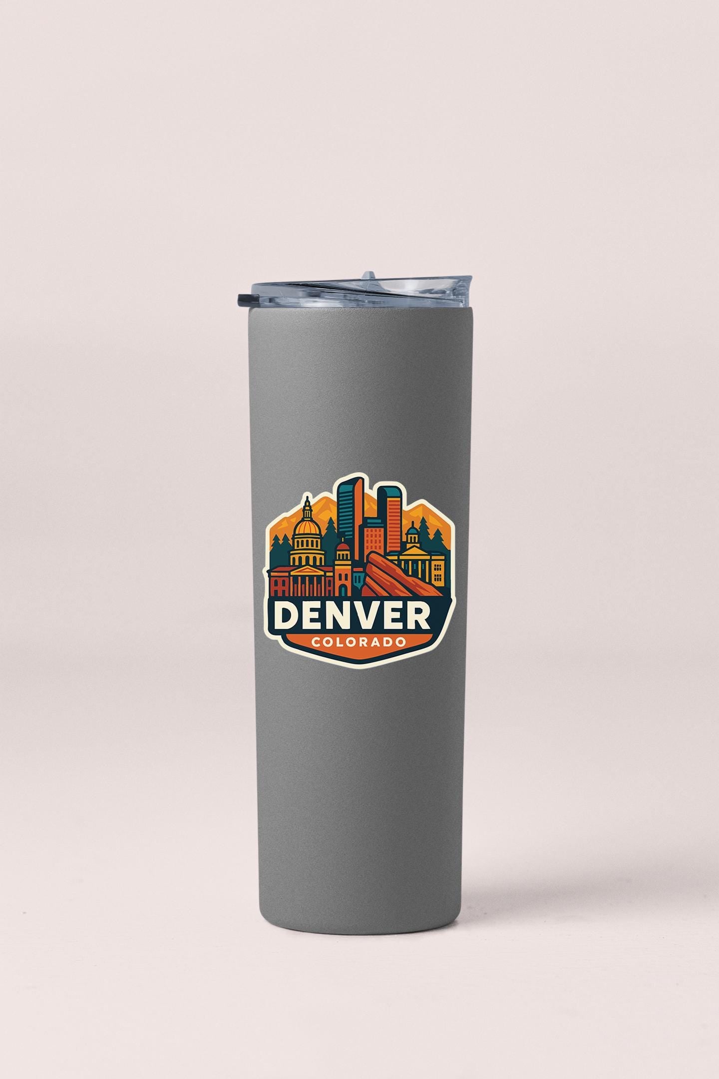 a stainless steel travel mug with the denver skyline in the background