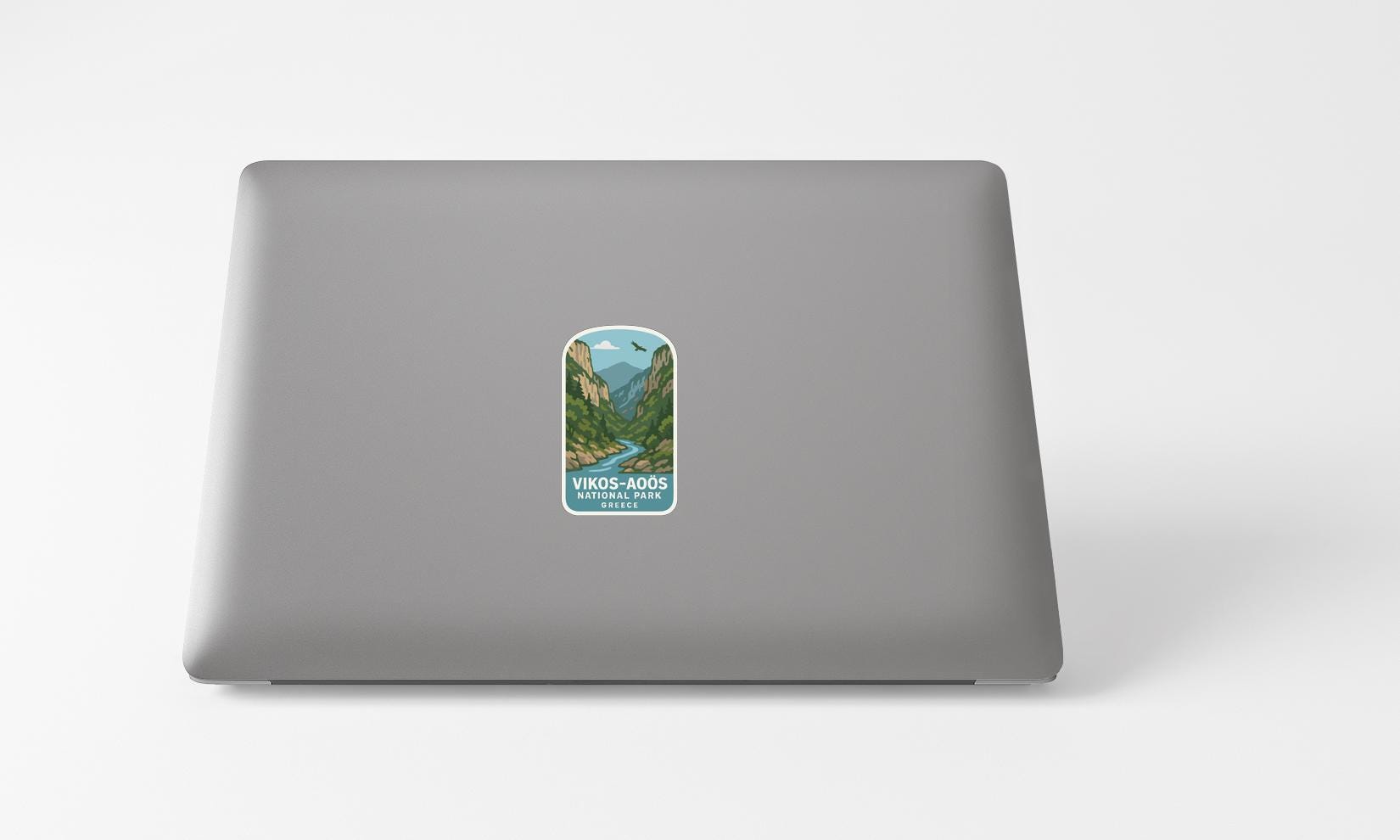 A sticker with a mountain landscape on a laptop.