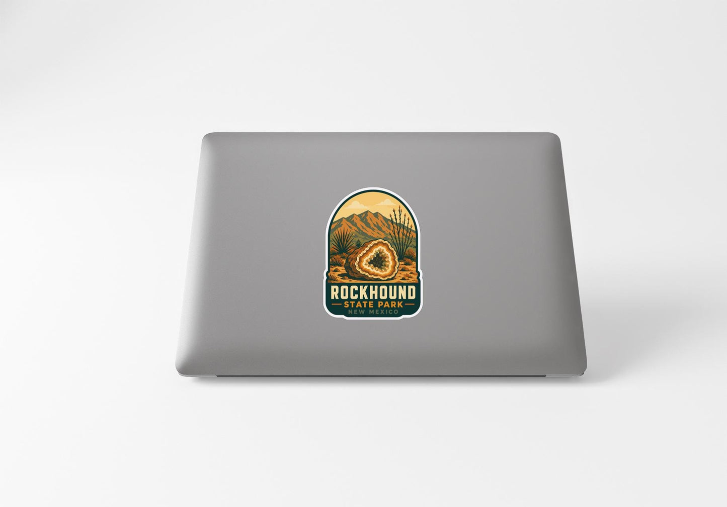 a sticker with a mountain landscape and the text "ROCKHOUND STATE PARK" on a laptop.