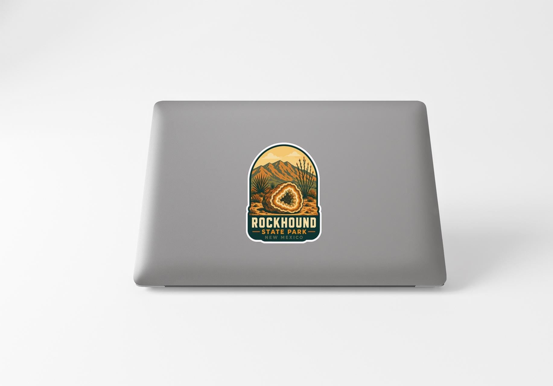 a sticker with a mountain landscape and the text "ROCKHOUND STATE PARK" on a laptop.