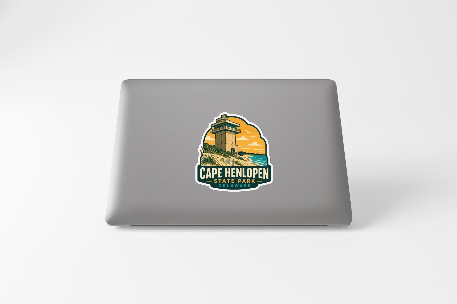 a sticker or decal of Cape Henlopen State Park on the back of a laptop computer.