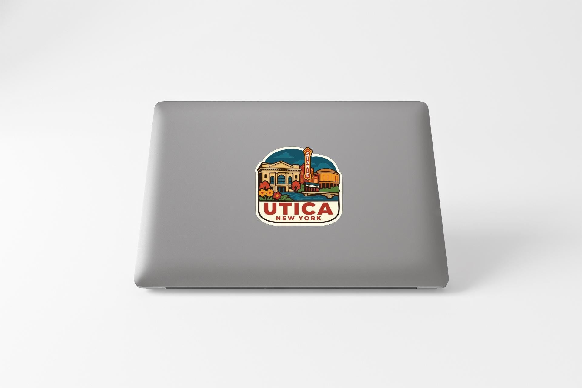 a sticker with a colorful illustration of a building and a sign that says "Utica New York".