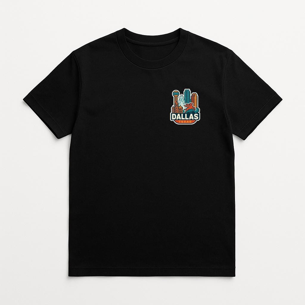A black t-shirt with a graphic of a city skyline and the word "DALLAS" printed on it.