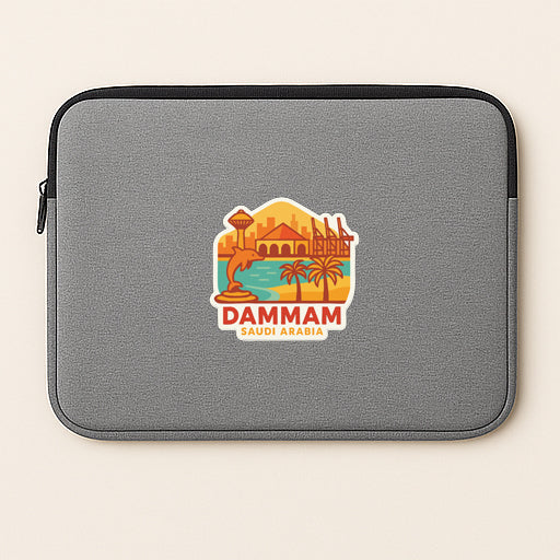 a gray laptop sleeve with a colorful sticker depicting a cityscape and palm trees, along with the text "DAMMAM SUDI ARABIA".