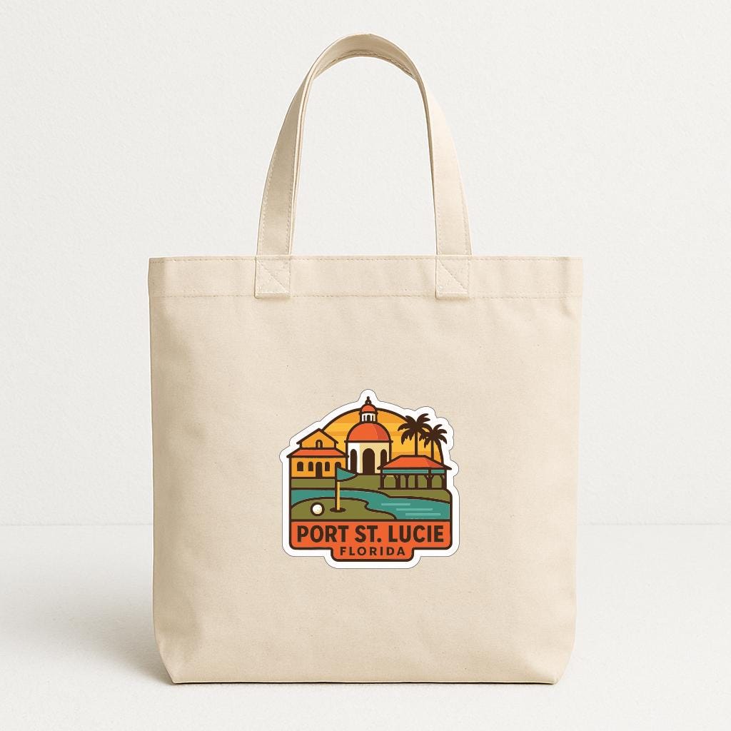 A beige tote bag with a printed design depicting a tropical scene, including a building, palm trees, and a body of water.