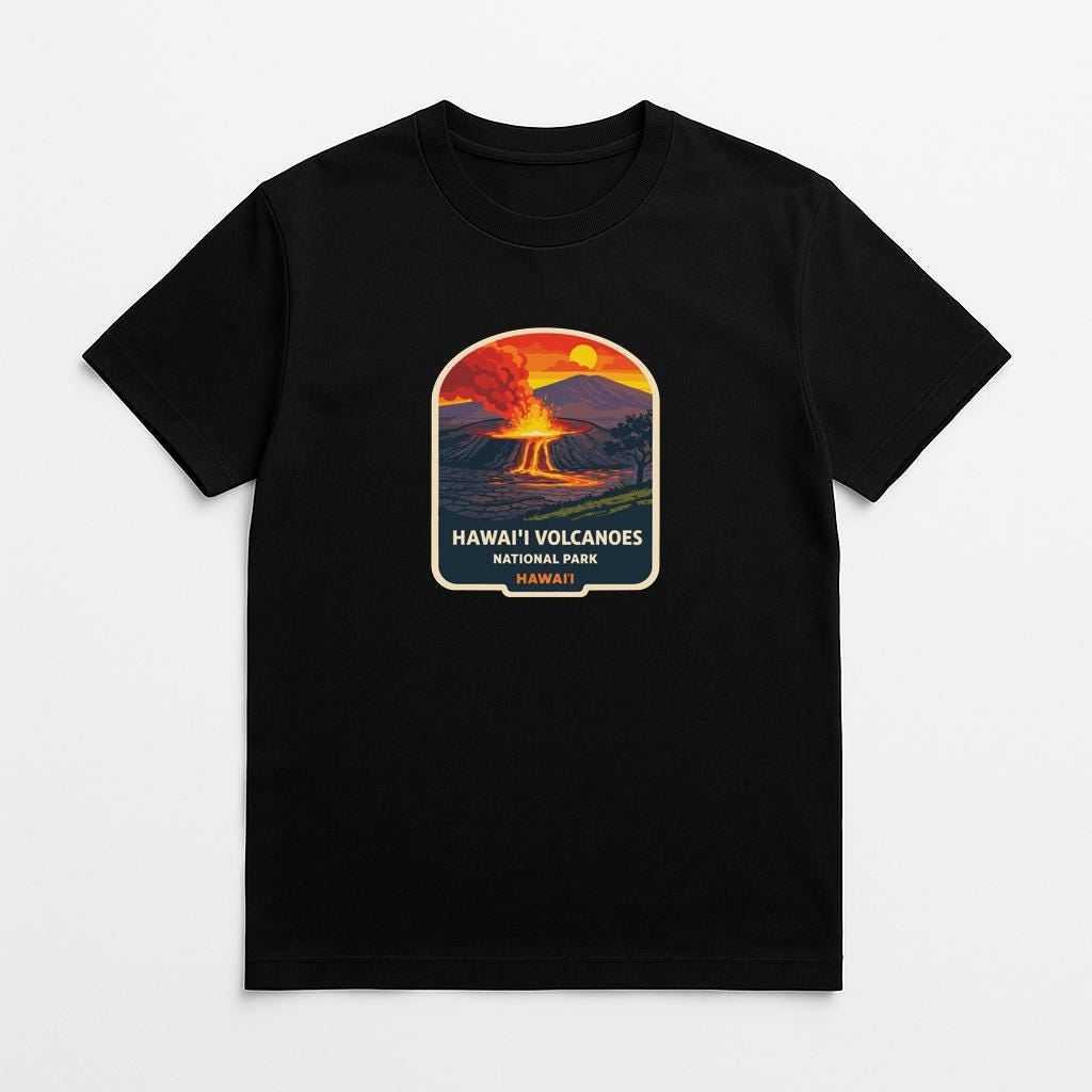 A black t-shirt with a graphic design depicting a Hawaiian volcano with a bright orange and yellow sunset in the background.