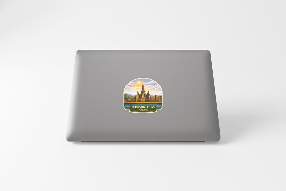 A sticker depicting a temple or monument with a scenic background, placed on the back of a laptop computer.