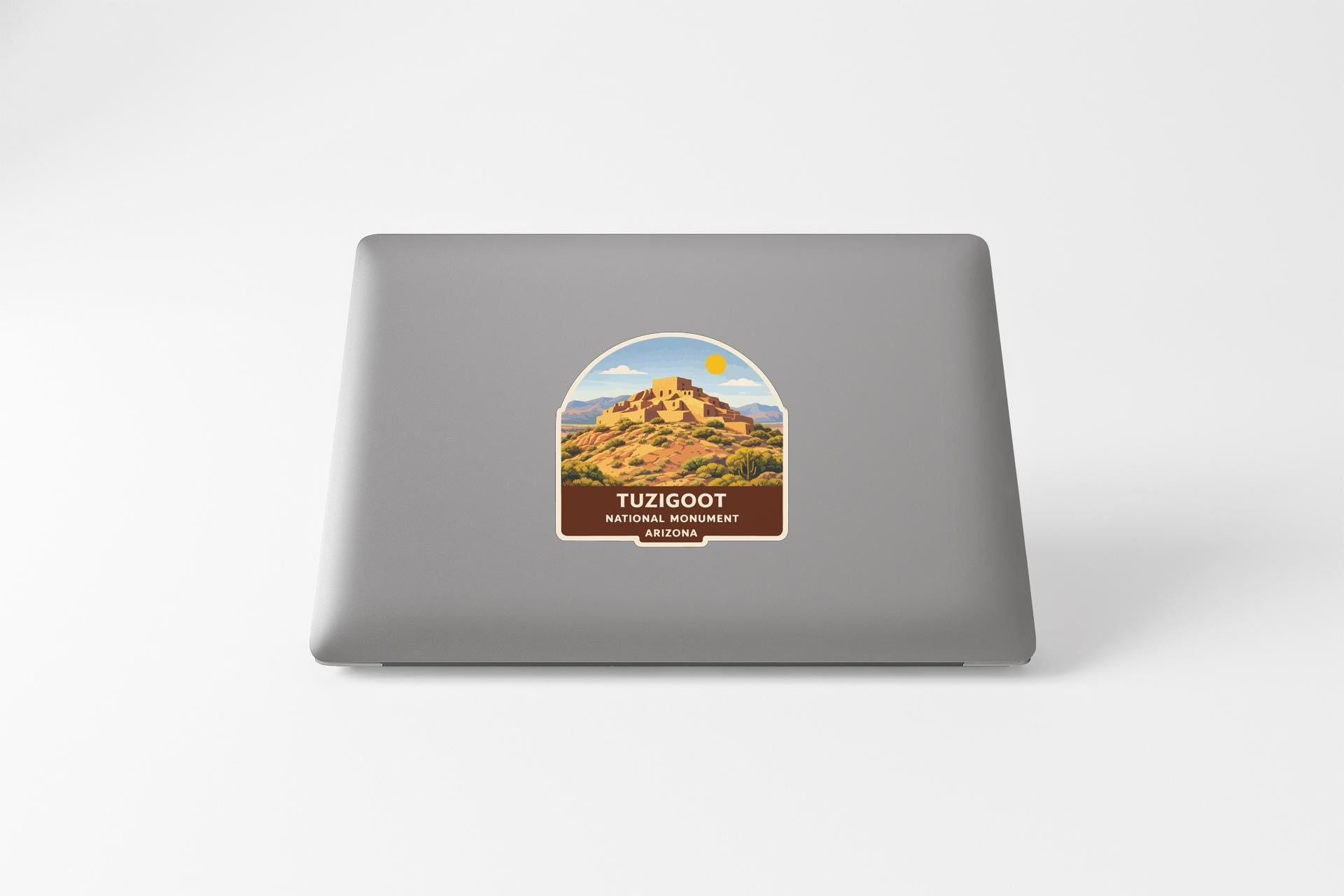 a sticker on the back of a laptop, depicting a desert landscape with a mountain in the background.
