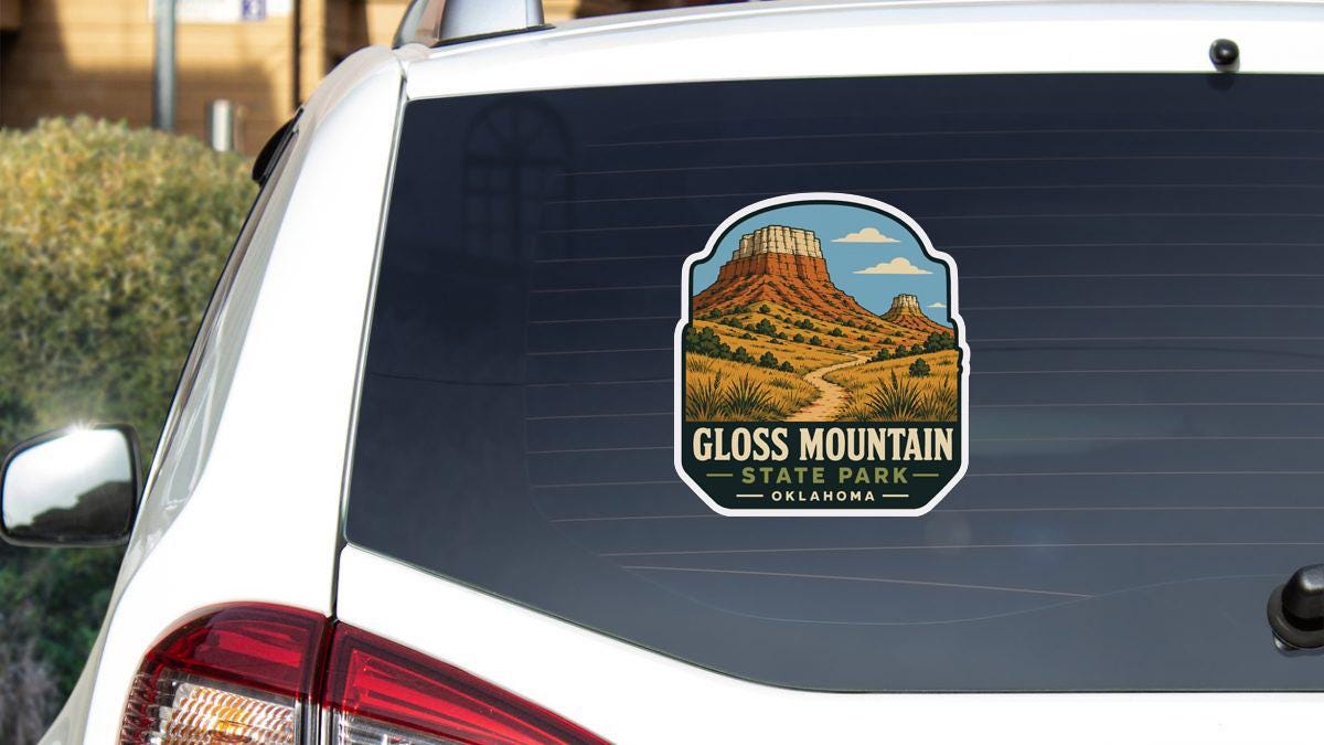 A sticker on the rear window of a white car, depicting Gloss Mountain State Park in Oklahoma.