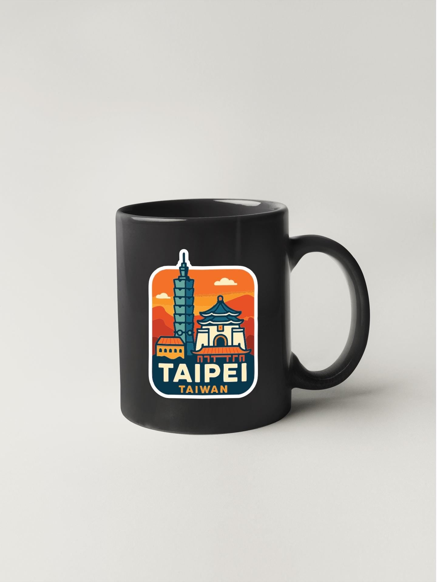 A black coffee mug with a colorful sticker depicting the skyline of Taipei, Taiwan.