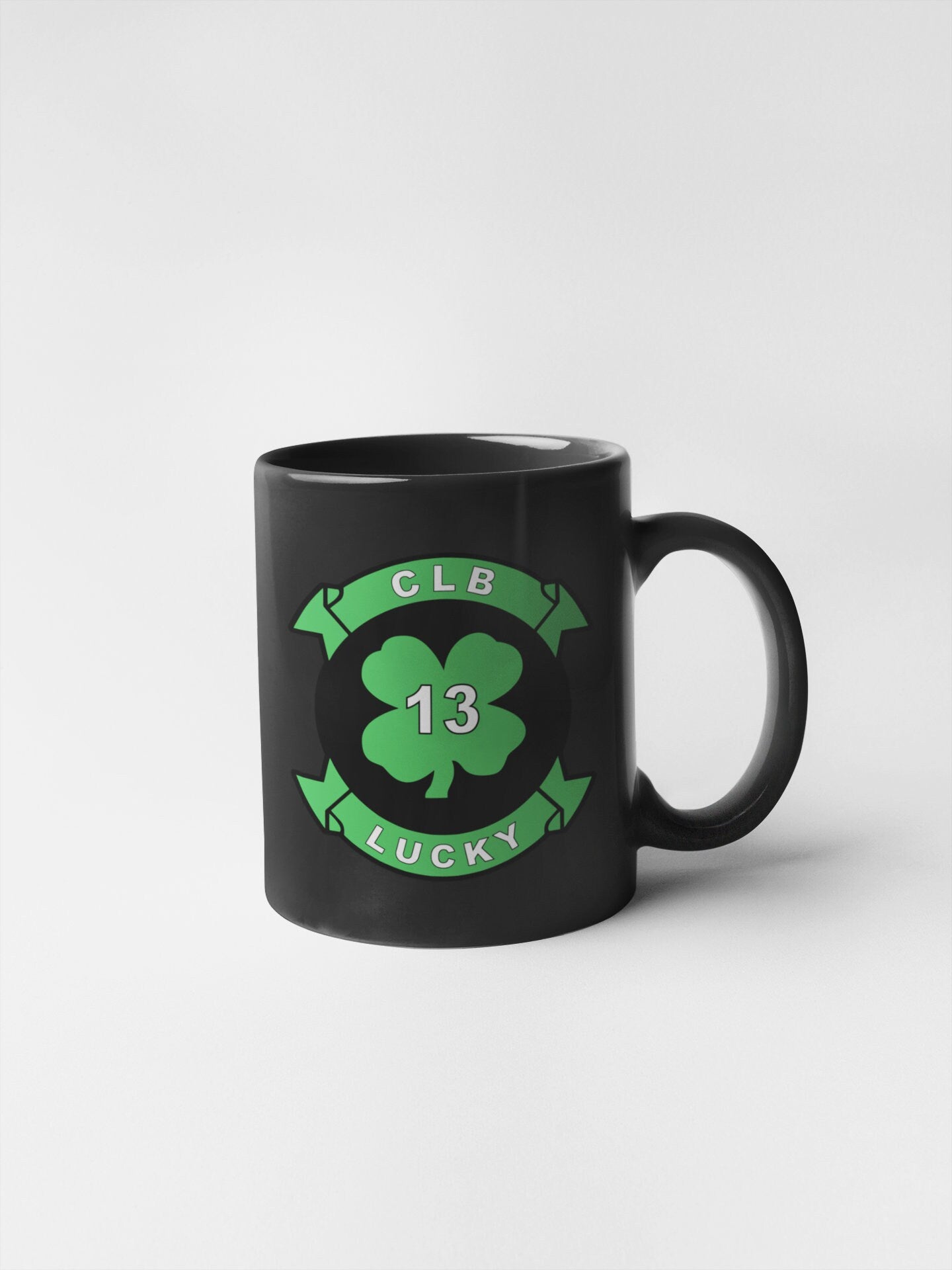 a black coffee mug with a clover on it