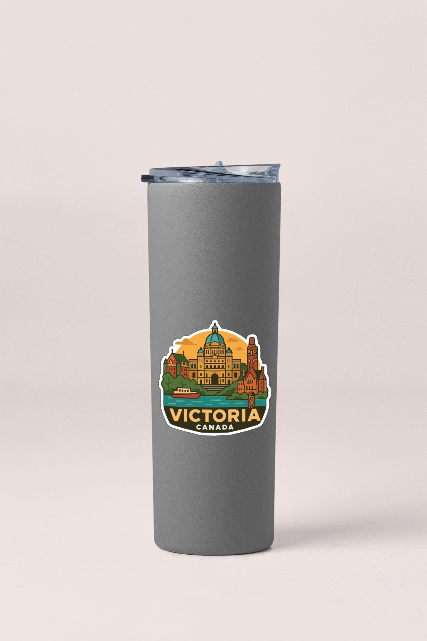 A gray insulated tumbler with a sticker depicting the city of Victoria, Canada.