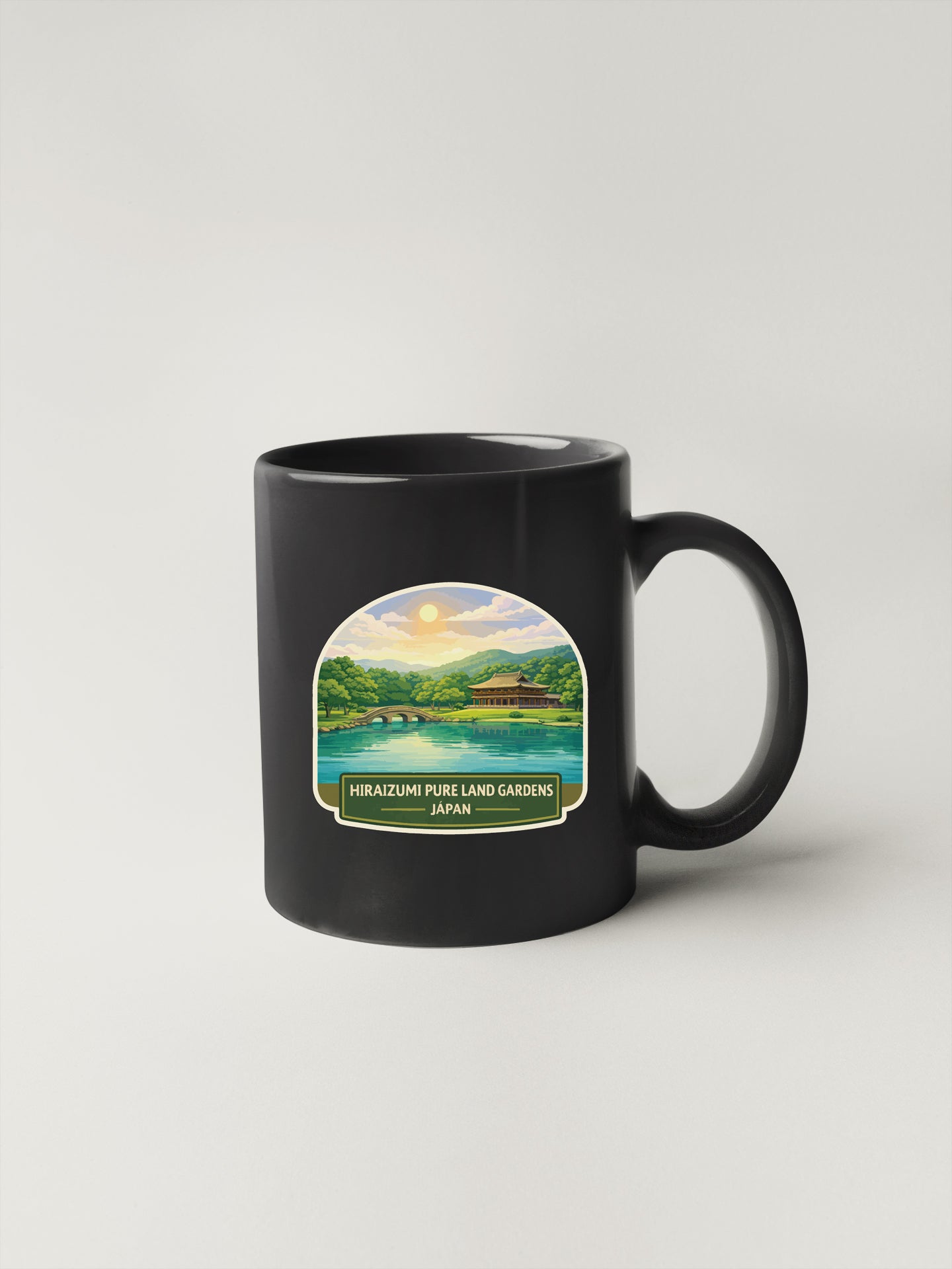 A black coffee mug with a printed image of a scenic landscape, including a lake, mountains, and a bridge, along with the text "Hirazumi Pure Land Gardens Japan".