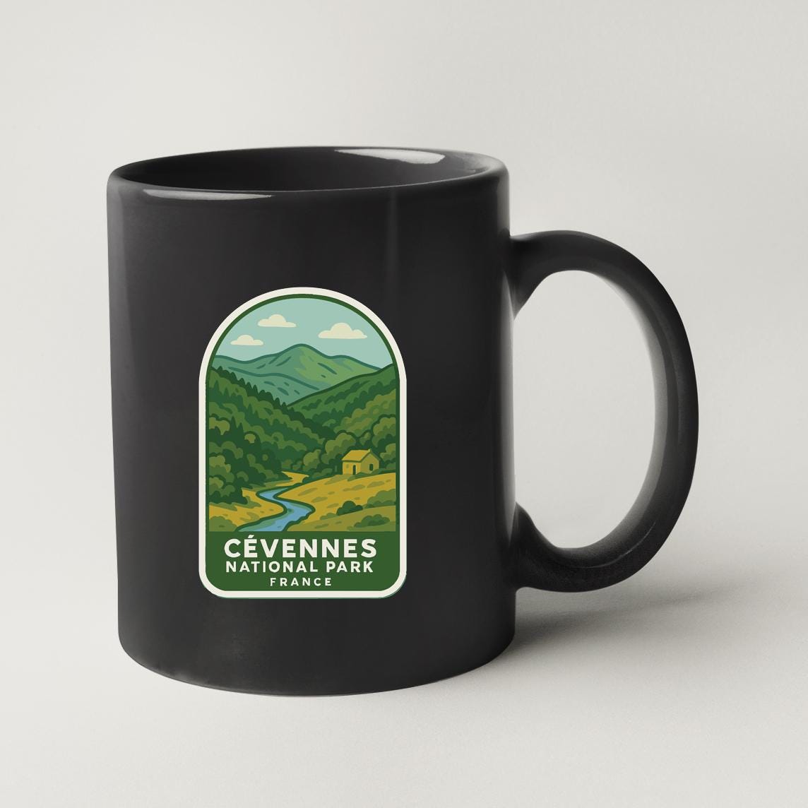 A black coffee mug with a label that says "CÉVENNE'S NATIONAL PARK FRANCE".