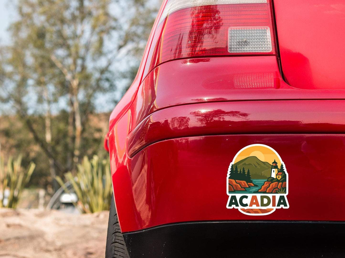 the rear end of a red car with a sticker on the trunk that says "ACADIA".
